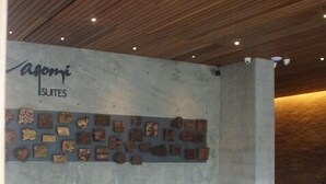 Un interior modern amb una zona d'estar que inclou sofàs i cadires, una taula de centre i una paret amb elements decoratius.