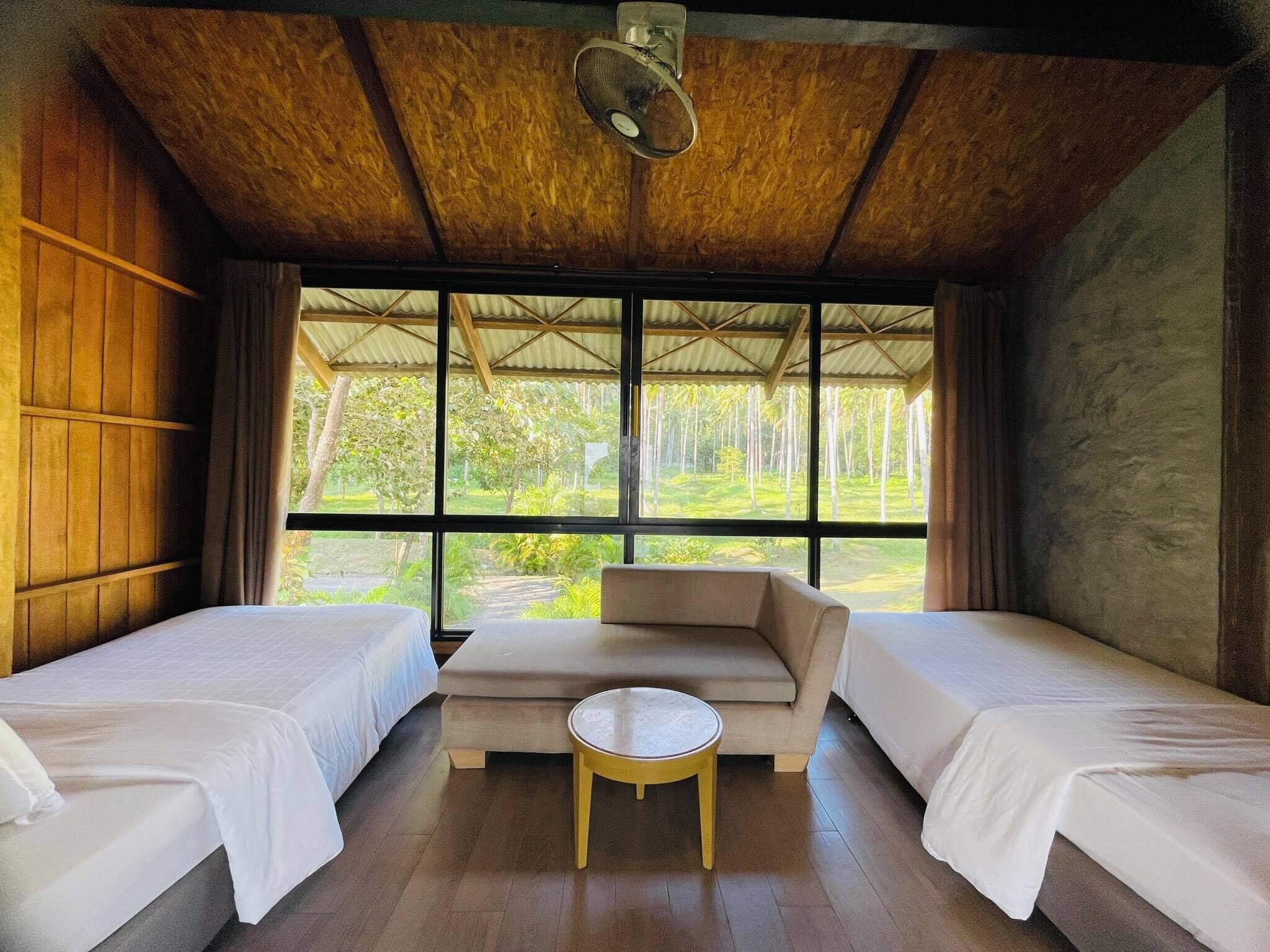A room with two beds, a sofa, and a small table.