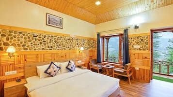 Relax in a serene bedroom with a large bed, wooden ceiling, and a view of the outdoors.