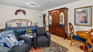 A bedroom with a bed, a chair, a dresser, a table, and a painting. - Parrish Room at  BNB (Yelm)