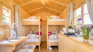 A cozy cabin with two bunk beds, a wooden desk, and a small kitchen area. - Ferienparadies Reifnhof (Riedering)