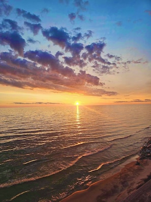 A sunset over a beach with calm waters reflecting the sky. - BEACH!, Lakefront Cottage, Huge Deck & Amazing Sunsets (Montague)