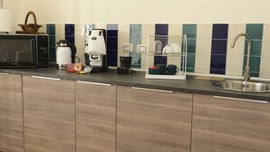 A modern kitchen with a microwave, coffee maker, and a dish rack. - B&B Fronte del Porto (Salerno)