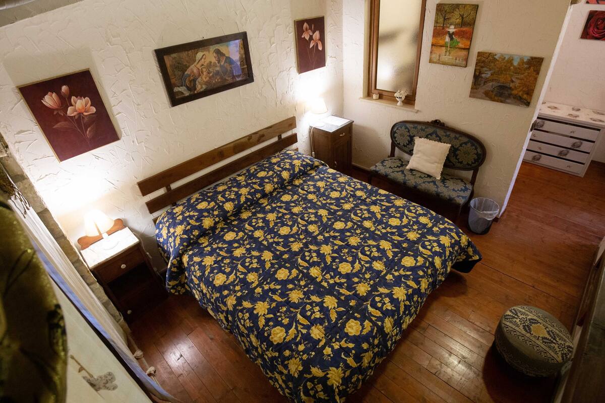 Un dormitorio con cama, mesita de noche, una silla y cómoda.