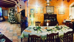 Comedor con una mesa redonda dispuesta para una comida, rodeado de sillas.