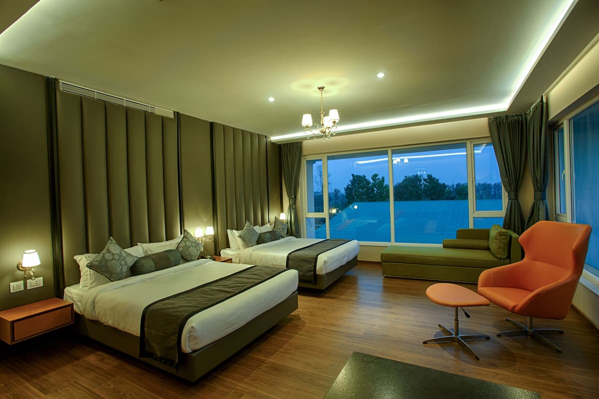 A modern bedroom with two beds, a sofa, and a chair.