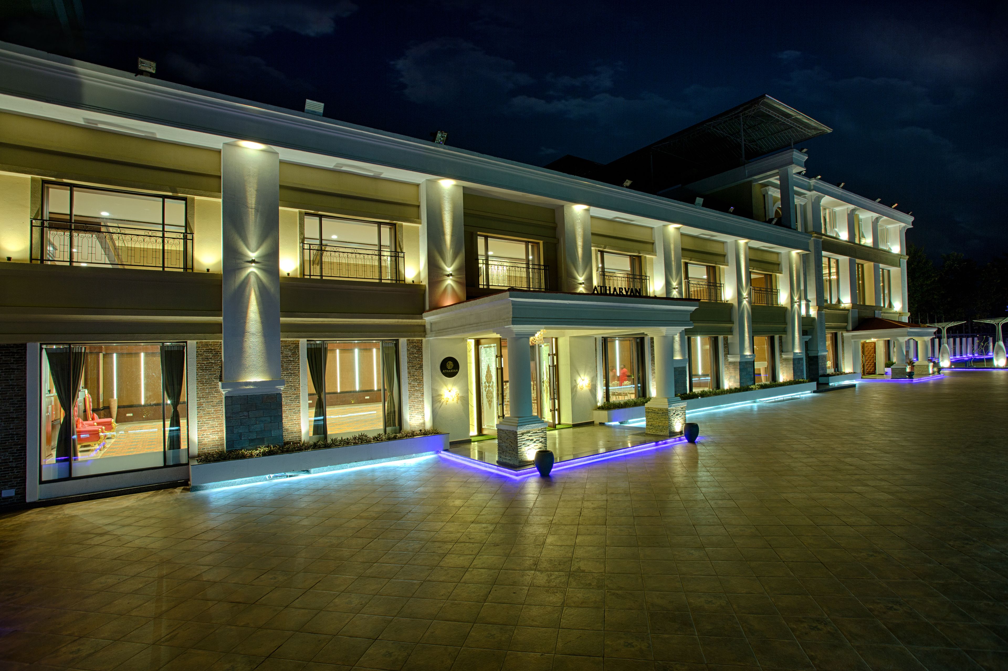 A multi-story hotel with a spacious courtyard, large windows, and modern lighting.