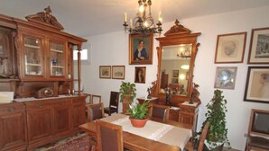 A traditional dining room with wooden furniture, a chandelier, and patterned rugs. - Lungolago by Interhome (Lavena Ponte Tresa)
