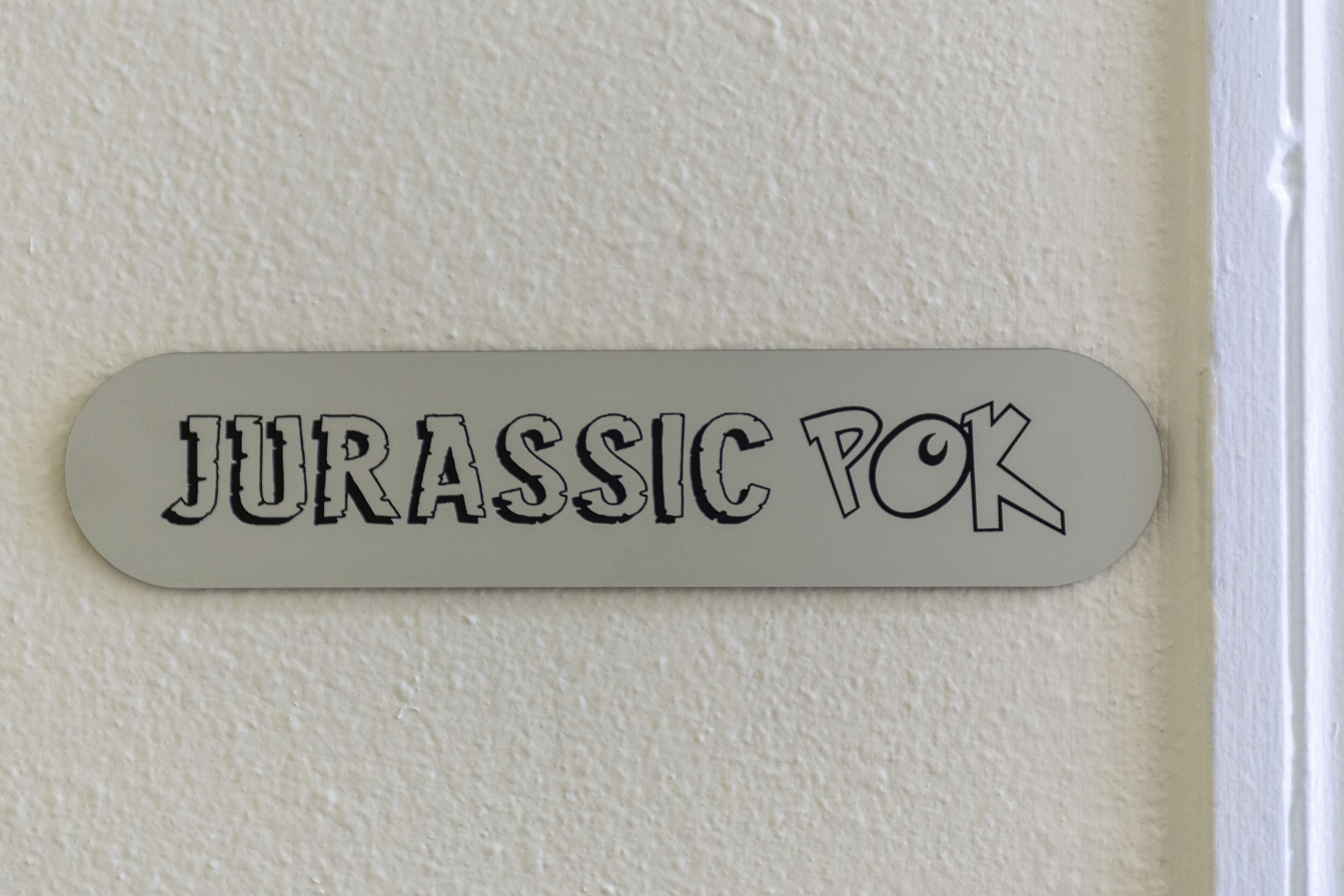 A sign with the text 'JURASSIC POK' on a wall.