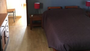 A bedroom with a bed, bedside tables, a lamp, and a wooden dresser. - First floor single house (Querciolo)