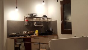 Keittiössä on pesuallas, liesi ja erilaisia keittiövälineitä. Siellä on myös ikkuna, josta on näkymä ulos.