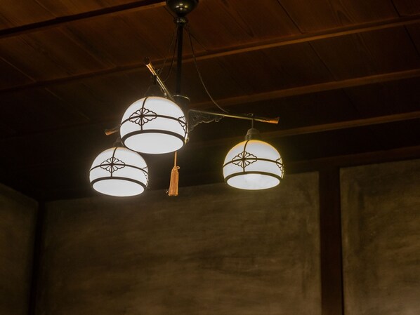 A ceiling with three spherical light fixtures, each with a decorative pattern and a tassel.