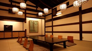 Een traditionele Japanse kamer met tatami vloerbedekking, een lage tafel en houten stoelen.