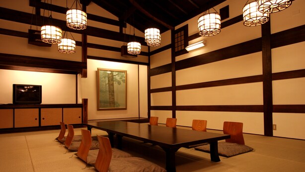 Een traditionele Japanse kamer met tatami vloerbedekking, een lage tafel en houten stoelen.