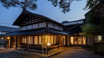 Un bâtiment traditionnel japonais doté d’un porche et de nombreuses fenêtres.