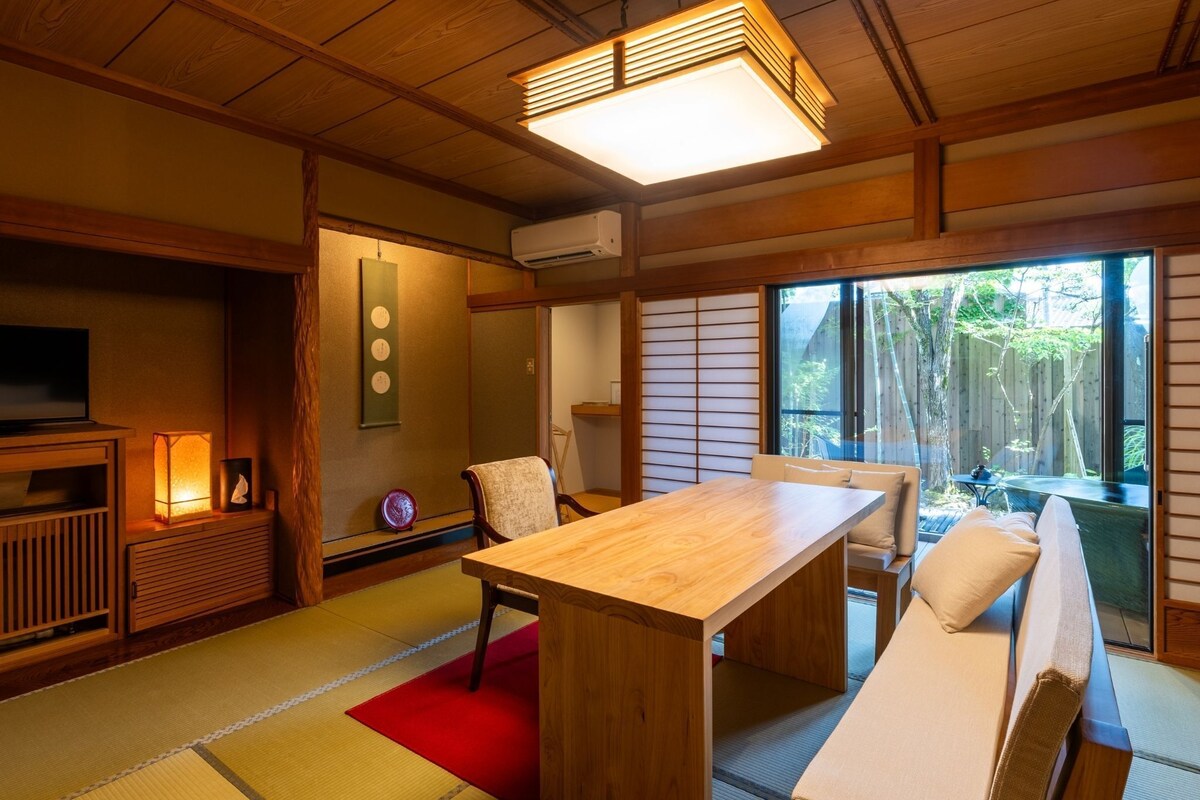 Ein traditioneller japanischer Raum mit Tatami-Böden, einem niedrigen Tisch und einer Couch.