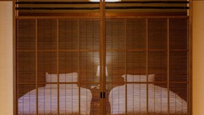 Een traditionele Japanse kamer met schuifdeuren en een bed.