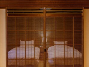 Une pièce de style japonais traditionnel, avec des portes coulissantes et un lit.