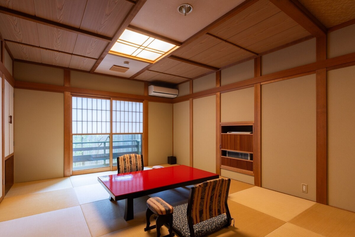Ein traditioneller japanischer Raum mit Tatami-Böden, einem niedrigen Tisch und Schiebetüren.
