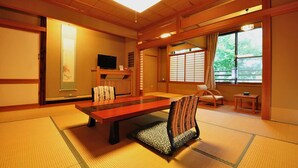 Een traditionele Japanse kamer met tatami vloerbedekking, een lage tafel en een kussenstoel.