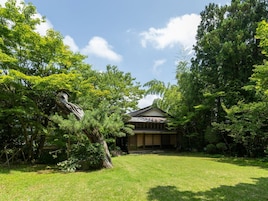 Una casa tradicional japonesa rodeada de exuberante vegetación.