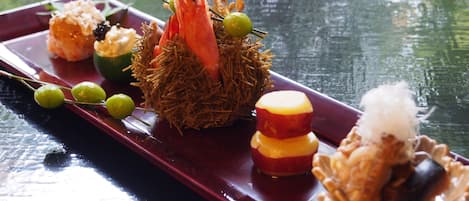 A variety of dishes on a tray, including a central decorative item with a bird and greenery, surrounded by smaller food items.