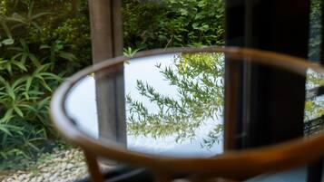 Una mesa de vidrio redonda con vista a la vegetación por la ventana.