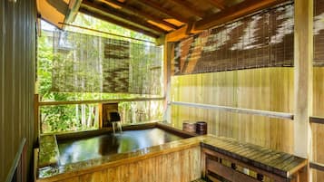 A traditional wooden hot spring bath with a wooden bench and a small wooden structure.