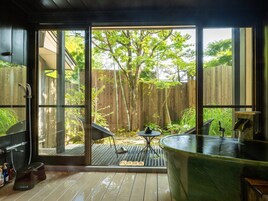 A modern outdoor kitchen with a large sink, a barbecue grill, and a table.