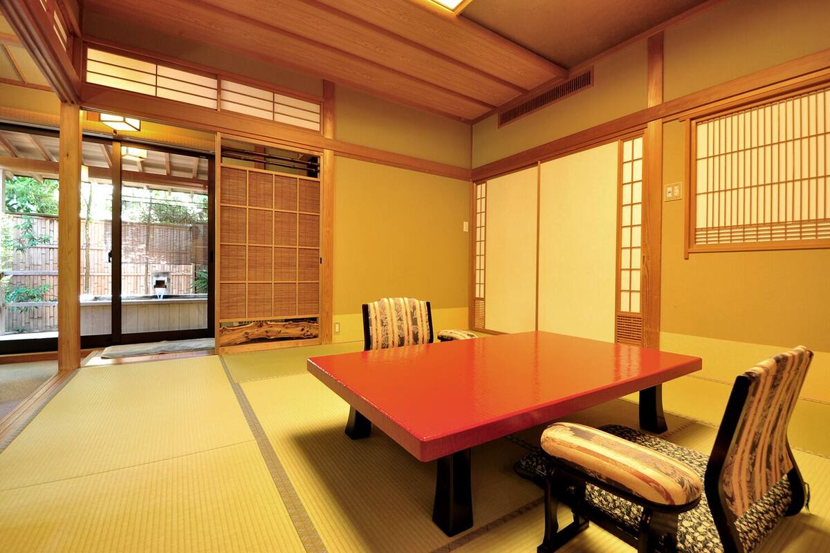 A traditional Japanese room with tatami flooring, a low wooden table, and shoji screens.