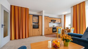 A modern apartment with a living room, kitchen, and dining area. - Haus Strandruh (Binz)