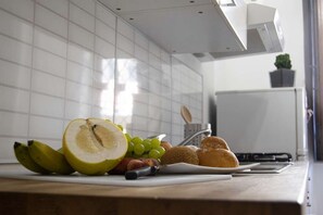 A kitchen counter with a variety of fruits and bread.