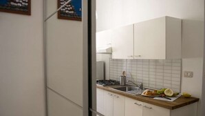 Eine moderne Küche mit weißen Schränken, einer Holzarbeitsplatte und einem Gasherd.