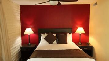 Relax in comfort with a large bed, two nightstands, and a ceiling fan for a cozy retreat.