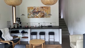 A modern kitchen with a central island, bar stools, and a dining area with a table and chairs. - Contemporary chalet with exceptional views and exposure 4 minutes from St Lary Soulan (Estensan)