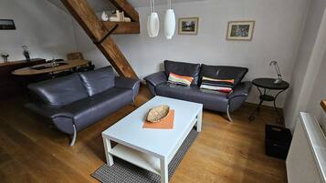 Una sala de estar con un sofá, una mesa de centro y una mesa de comedor.