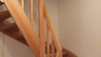 Una escalera de madera con barandilla y un pequeño adorno en la pared.