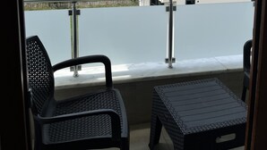 A balcony with two wicker chairs and a small table, overlooking a residential area with buildings and a clear sky. - Engin Otel (Kandira)