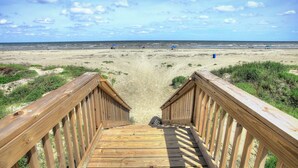 A wooden staircase leading to a beach with a clear sky. - Salty Air Retreat - Fabulous Beach Views - Brand New Elevator (Galveston)