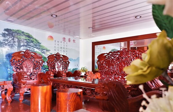 Una habitación tradicional china con muebles de madera ornamentados, un espejo grande y caligrafía en las paredes.