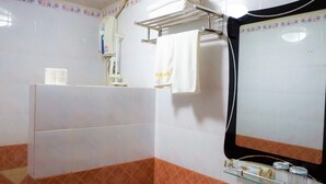 Un baño con lavamanos blanco, un espejo y un perchero para toallas.