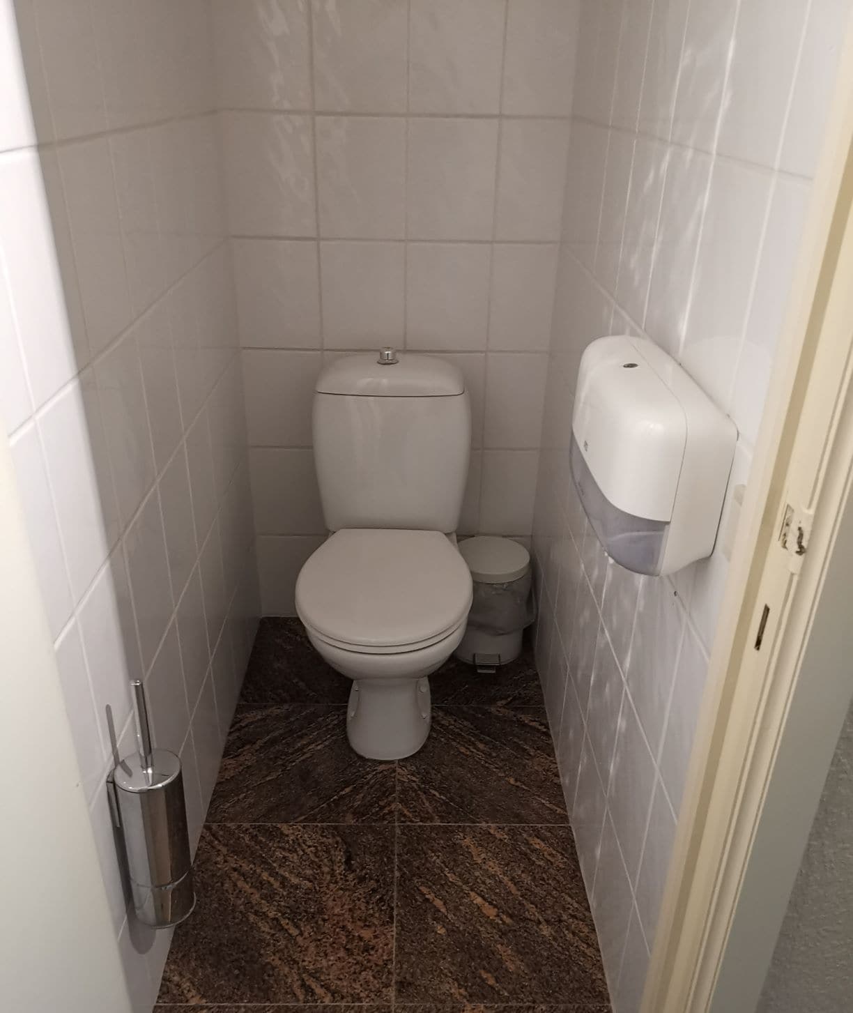 Un baño pequeño y moderno con inodoro, bidé y secamanos.