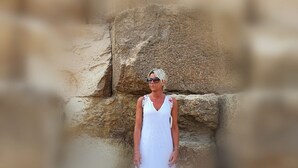 Una persona in piedi di fronte a un muro di pietra.