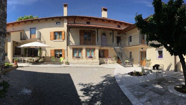 Un edificio a due piani con un cortile interno, posti a sedere all'aperto e una scala che conduce al piano superiore.