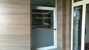 A reception area with a glass door and a sign that reads "Reception". - The Residence Galliate (Galliate)