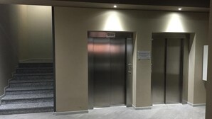 A modern elevator area with a staircase on the left. - The Residence Galliate (Galliate)