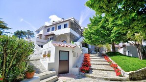 A traditional white building with a stone staircase leading to a door. - Casa Spirea A: A characteristic and welcoming two-story apartment situated in a quiet location, a few minutes from the town center, with Free WI-FI. (Massa Lubrense)