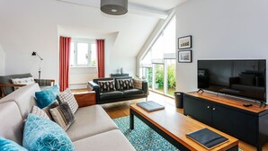 A modern living room with a sofa, coffee table, and TV. - Ship Bungalow (Minehead)