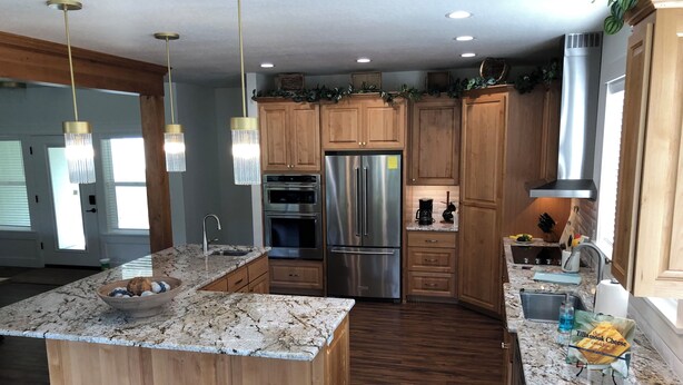 A modern kitchen with wooden cabinets, stainless steel appliances, and a granite countertop. - CHARMING AND SPECTACULAR RIVERFRONT HOUSE, BEAUTIFUL IN ANY SEASON OF THE YEAR! (Leaburg)