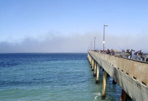 A pier extending into the water with people fishing.